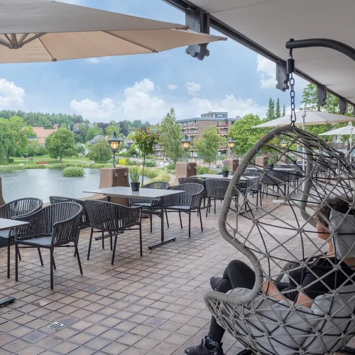 Terrasse des Restaurants im Hotel am Kranichsee mit Blick auf den Kranichsee, Sitzgelegenheiten und Hängesessel
